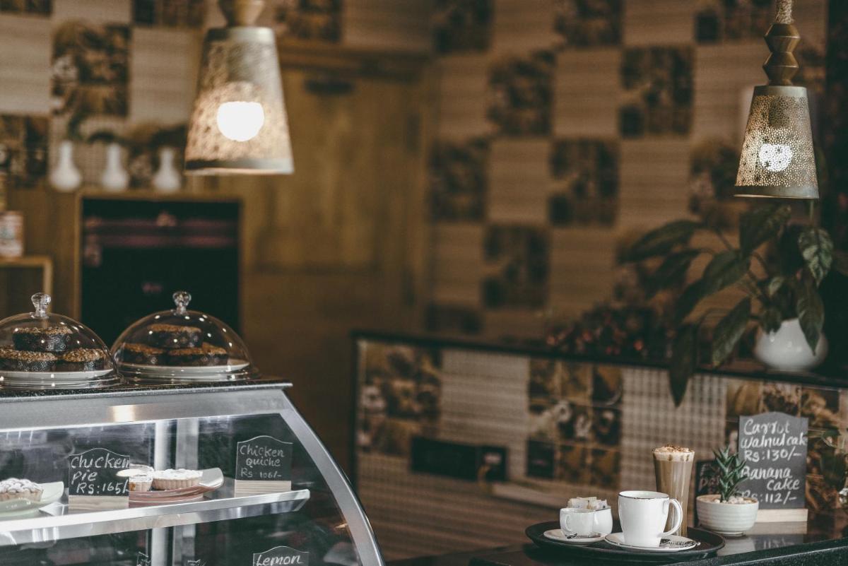 a restaurant with a counter with cups and plates of food at The Panoramic Getaway in Munnar
