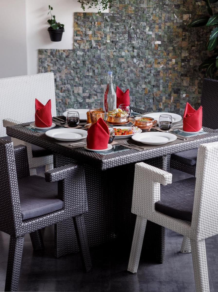 a table with plates of food and red pillows on it at The Panoramic Getaway in Munnar