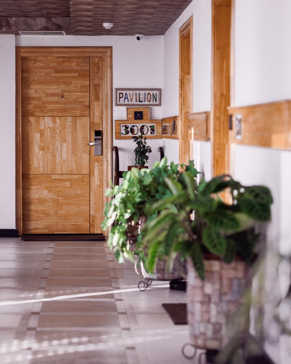 a hallway with a wooden door and potted plants at The Panoramic Getaway in Munnar