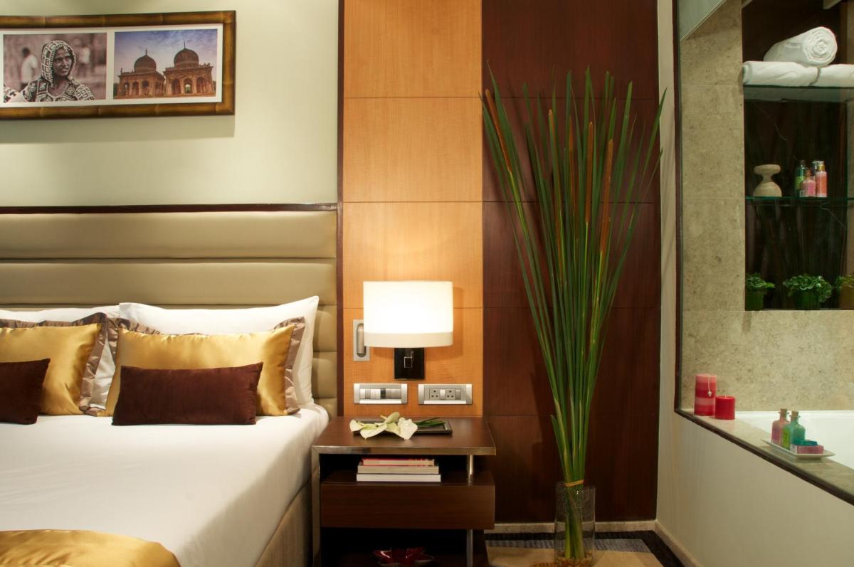 a bedroom with a bed and a table with a lamp at Vivanta Hyderabad, Begumpet in Hyderabad a bedroom with a bed and a table with a lamp at Vivanta Hyderabad, Begumpet in Hyderabad