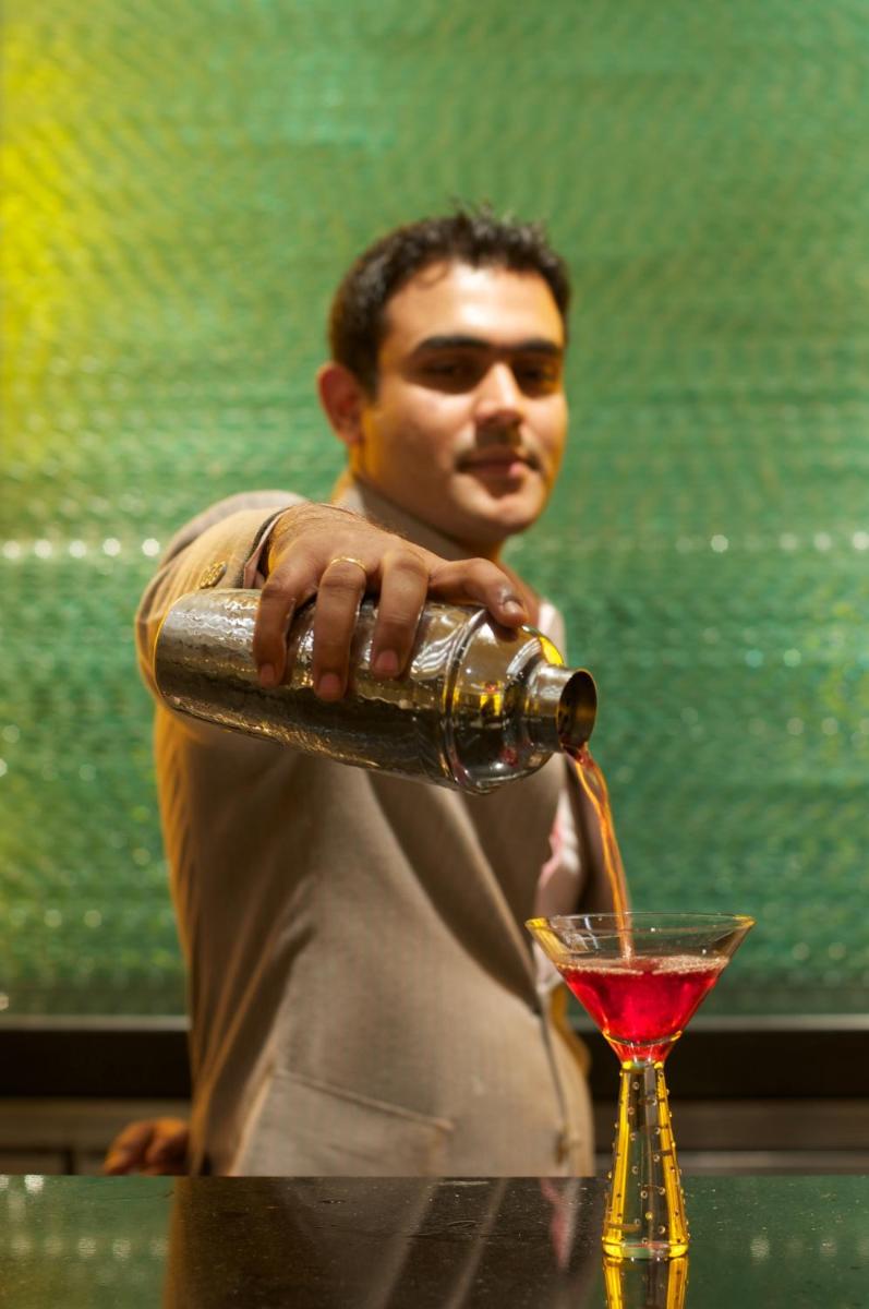 a man pouring a drink into a martini glass at Vivanta Hyderabad, Begumpet in Hyderabad a man pouring a drink into a martini glass at Vivanta Hyderabad, Begumpet in Hyderabad