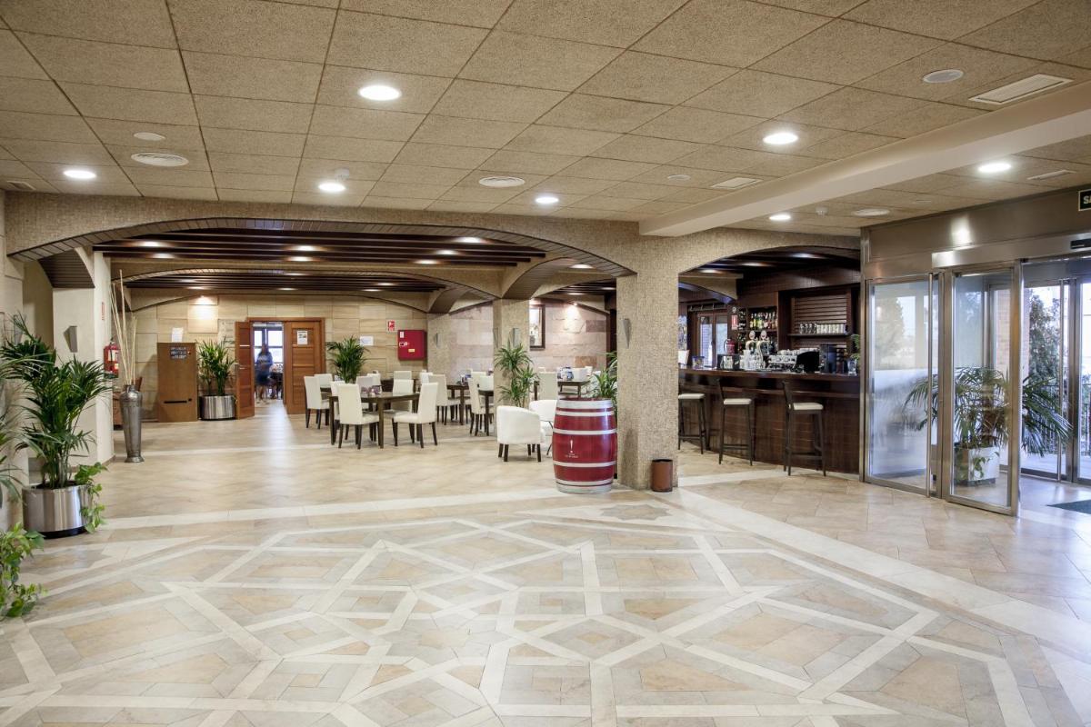 Un vestíbulo con un restaurante con mesas y sillas. en Hotel Comendador, en Carranque 84 fotos más
