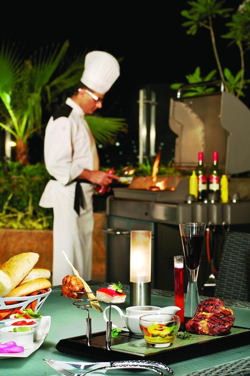 a chef standing in a kitchen preparing food at Vivanta Hyderabad, Begumpet in Hyderabad a chef standing in a kitchen preparing food at Vivanta Hyderabad, Begumpet in Hyderabad
