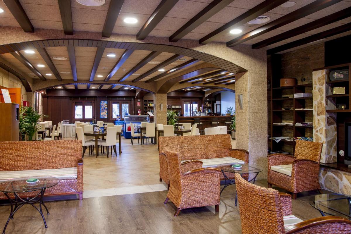 Un restaurante con mesas y sillas en una habitación. en Hotel Comendador, en Carranque