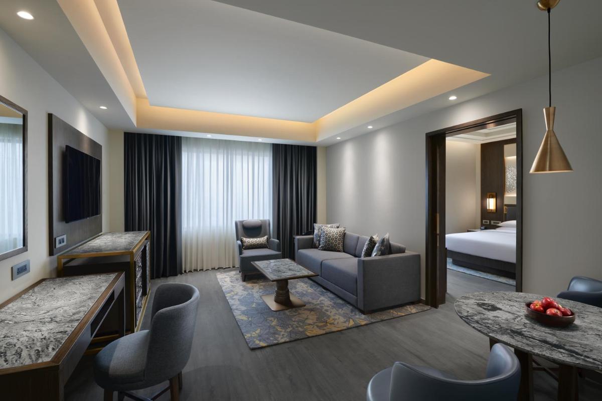 a hotel room with a couch and a bed at Hyatt Regency Jaipur Mansarovar in Jaipur a hotel room with a couch and a bed at Hyatt Regency Jaipur Mansarovar in Jaipur