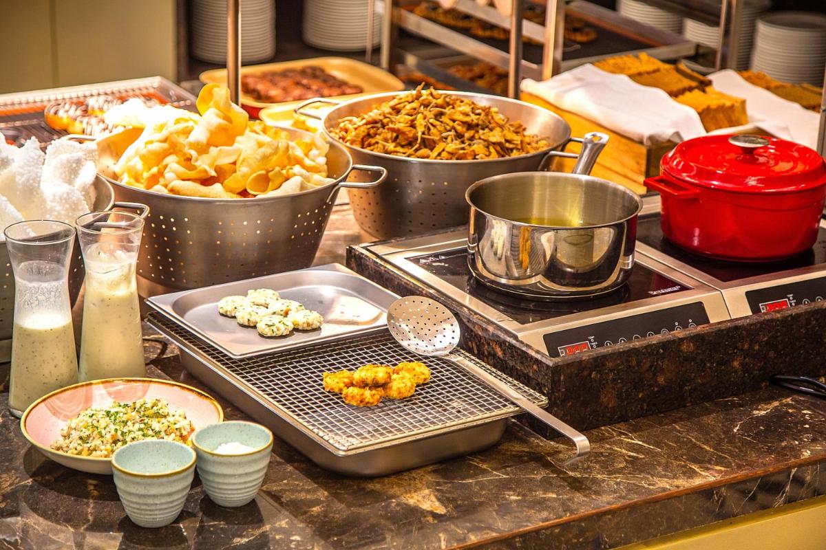 a kitchen counter with several pans of food on it at Hyatt Regency Jaipur Mansarovar in Jaipur a kitchen counter with several pans of food on it at Hyatt Regency Jaipur Mansarovar in Jaipur