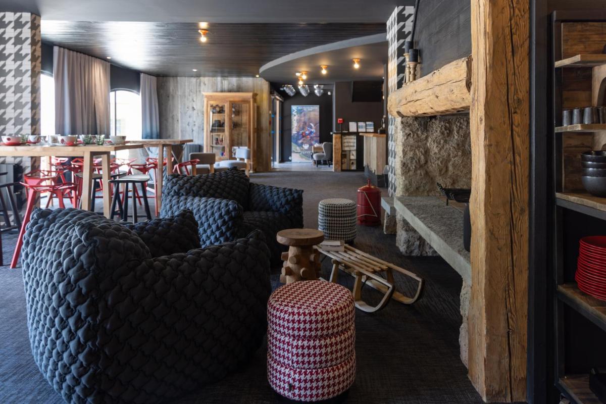 une chambre avec des canapés, une table et un bar dans l'établissement Hôtel Le Cristal Lodge - TERRESENS, à Saint-Chaffrey