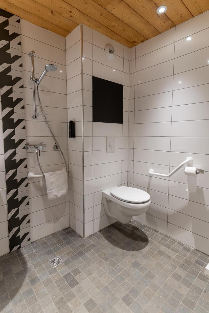 une salle de bain avec toilettes et douche dans l'établissement Hôtel Le Cristal Lodge - TERRESENS, à Saint-Chaffrey