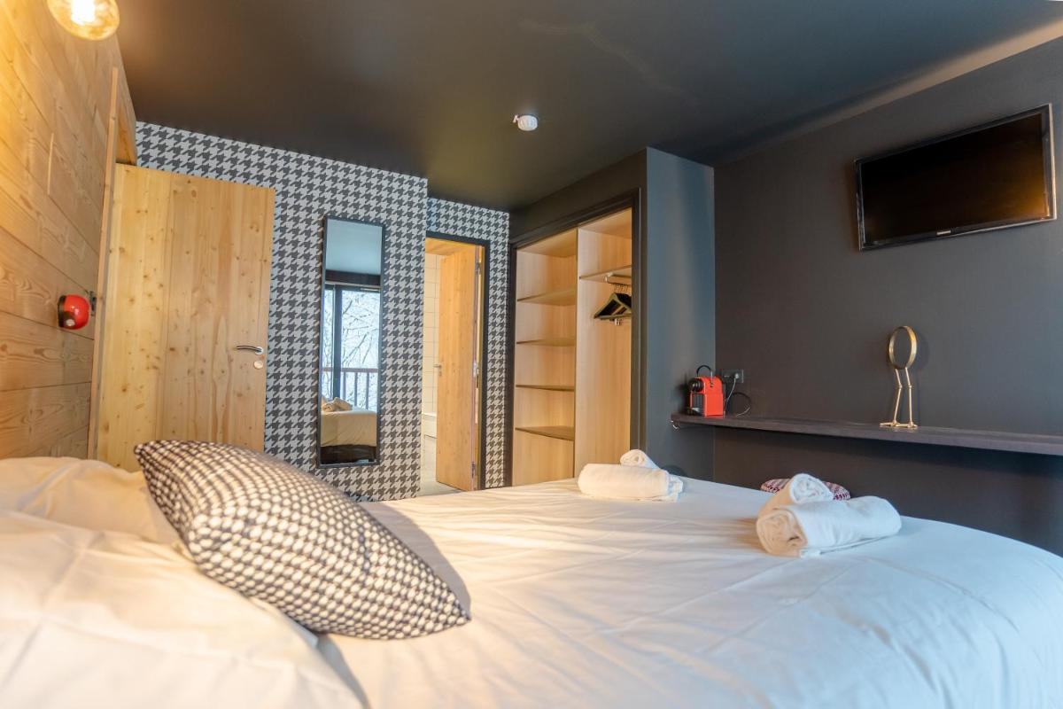 Un ou plusieurs lits dans un hébergement de l'établissement Hôtel Le Cristal Lodge - TERRESENS