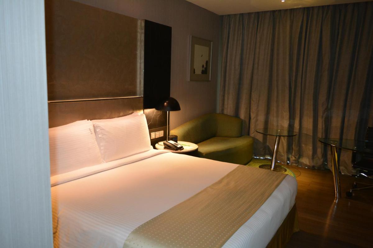 a hotel room with a bed and a chair at Holiday Inn New Delhi Aerocity by IHG in New Delhi