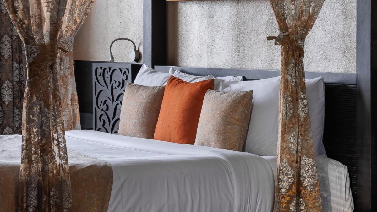 a bedroom with a bed with white sheets and pillows at The Panoramic Getaway in Munnar