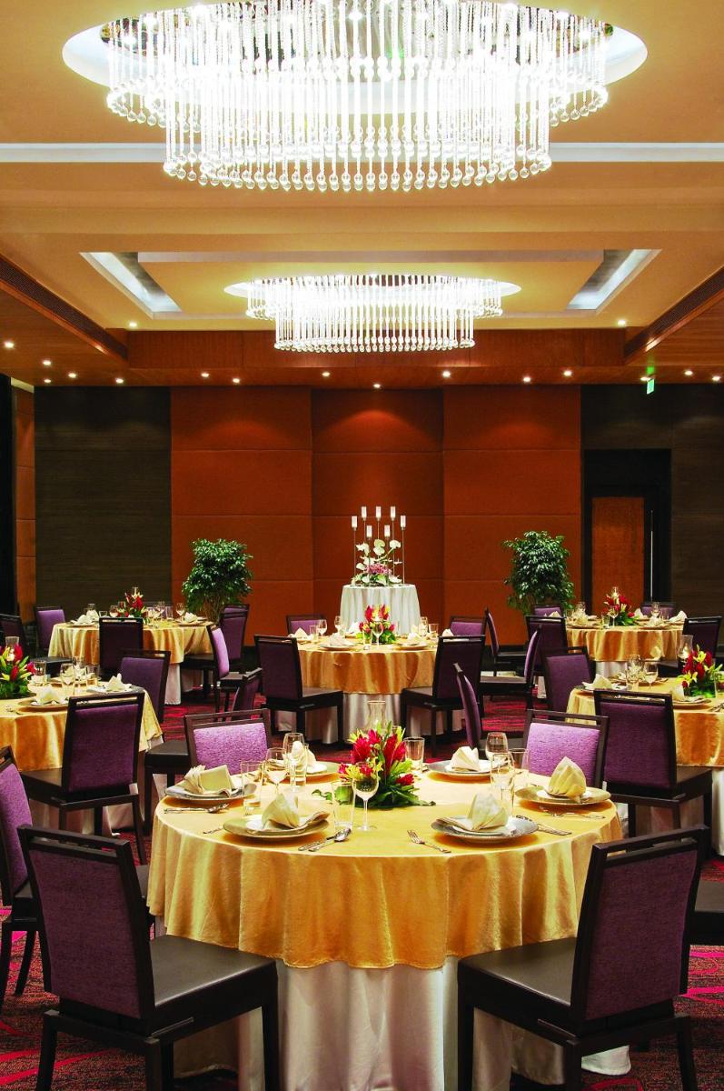 a dining room with tables and chairs and a chandelier at Vivanta Hyderabad, Begumpet in Hyderabad a dining room with tables and chairs and a chandelier at Vivanta Hyderabad, Begumpet in Hyderabad