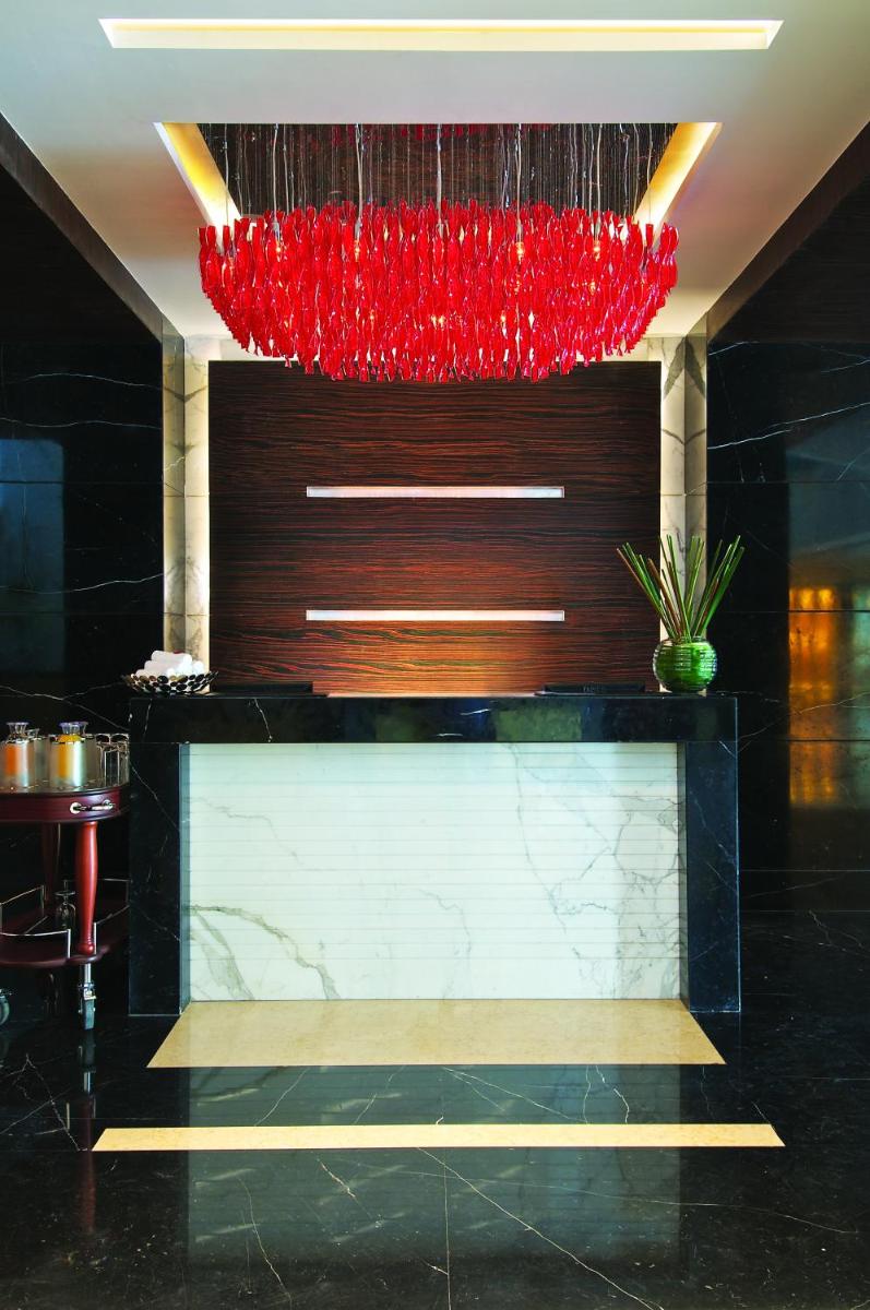 a lobby with a red chandelier above a counter at Vivanta Hyderabad, Begumpet in Hyderabad a lobby with a red chandelier above a counter at Vivanta Hyderabad, Begumpet in Hyderabad