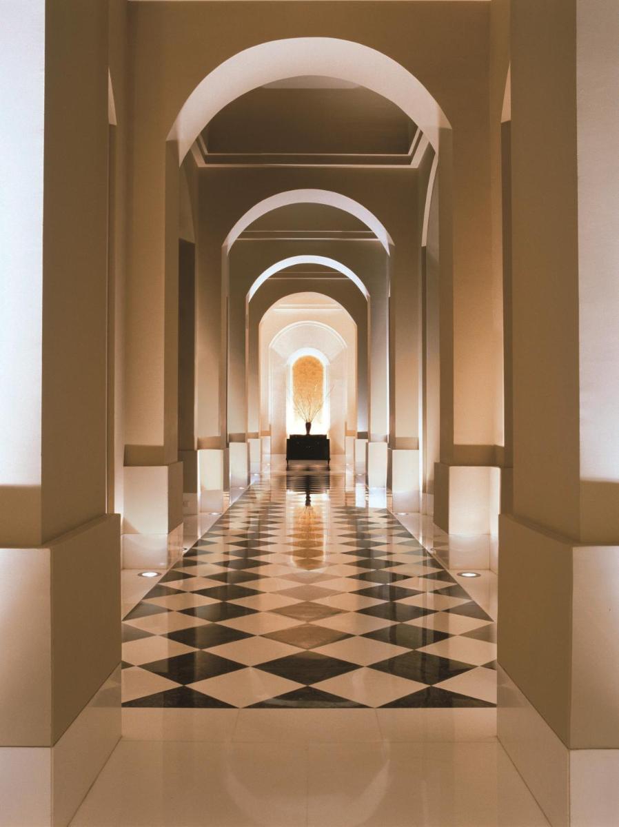 a hallway of a hotel with a black and white checkerboard floor at Trident Gurgaon in Gurgaon