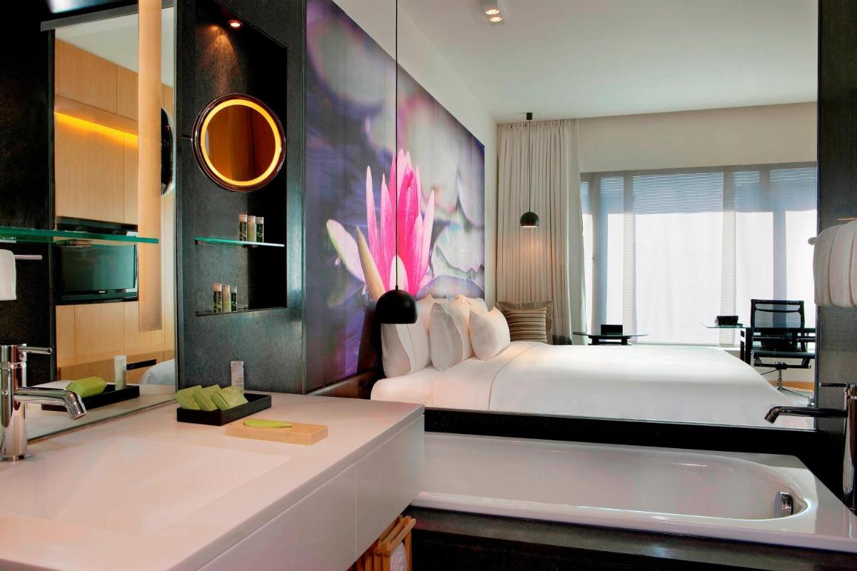 a bedroom with a bed and a sink and a tub at The Westin Hyderabad Mindspace in Hyderabad