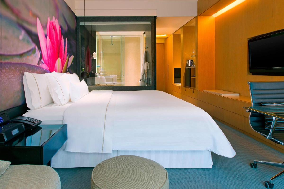 a bedroom with a large white bed and a television at The Westin Hyderabad Mindspace in Hyderabad