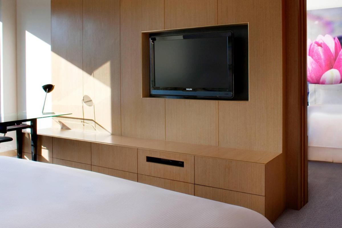a room with a tv and a bed and a desk at The Westin Hyderabad Mindspace in Hyderabad