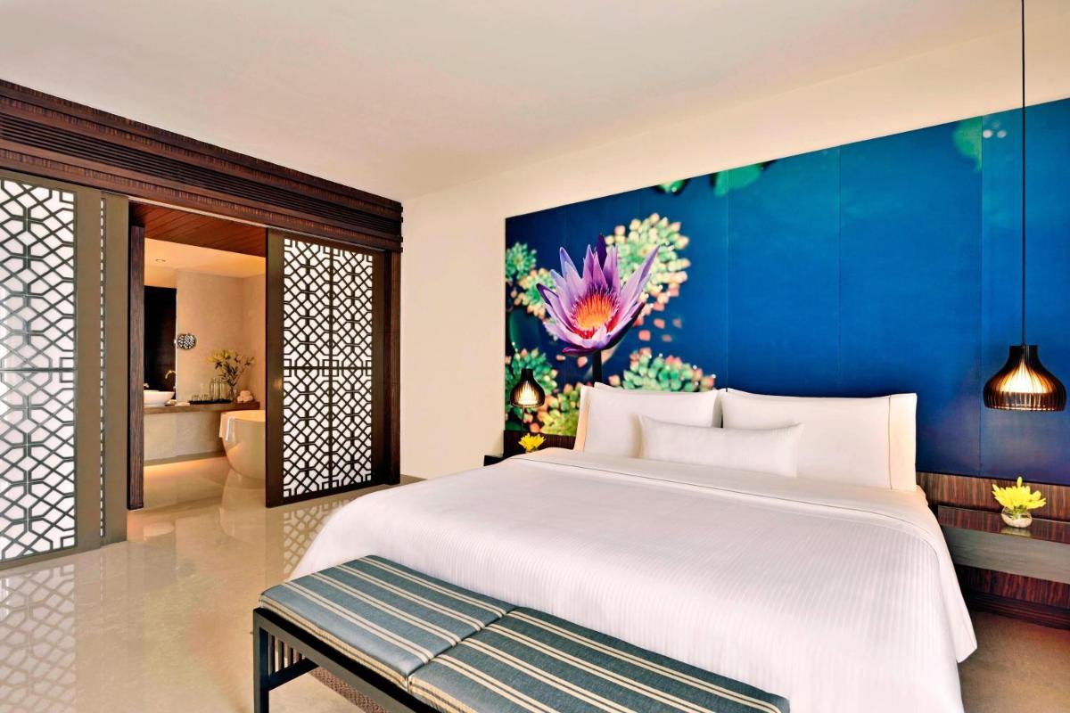 a bedroom with a large white bed and a blue wall at The Westin Hyderabad Mindspace in Hyderabad