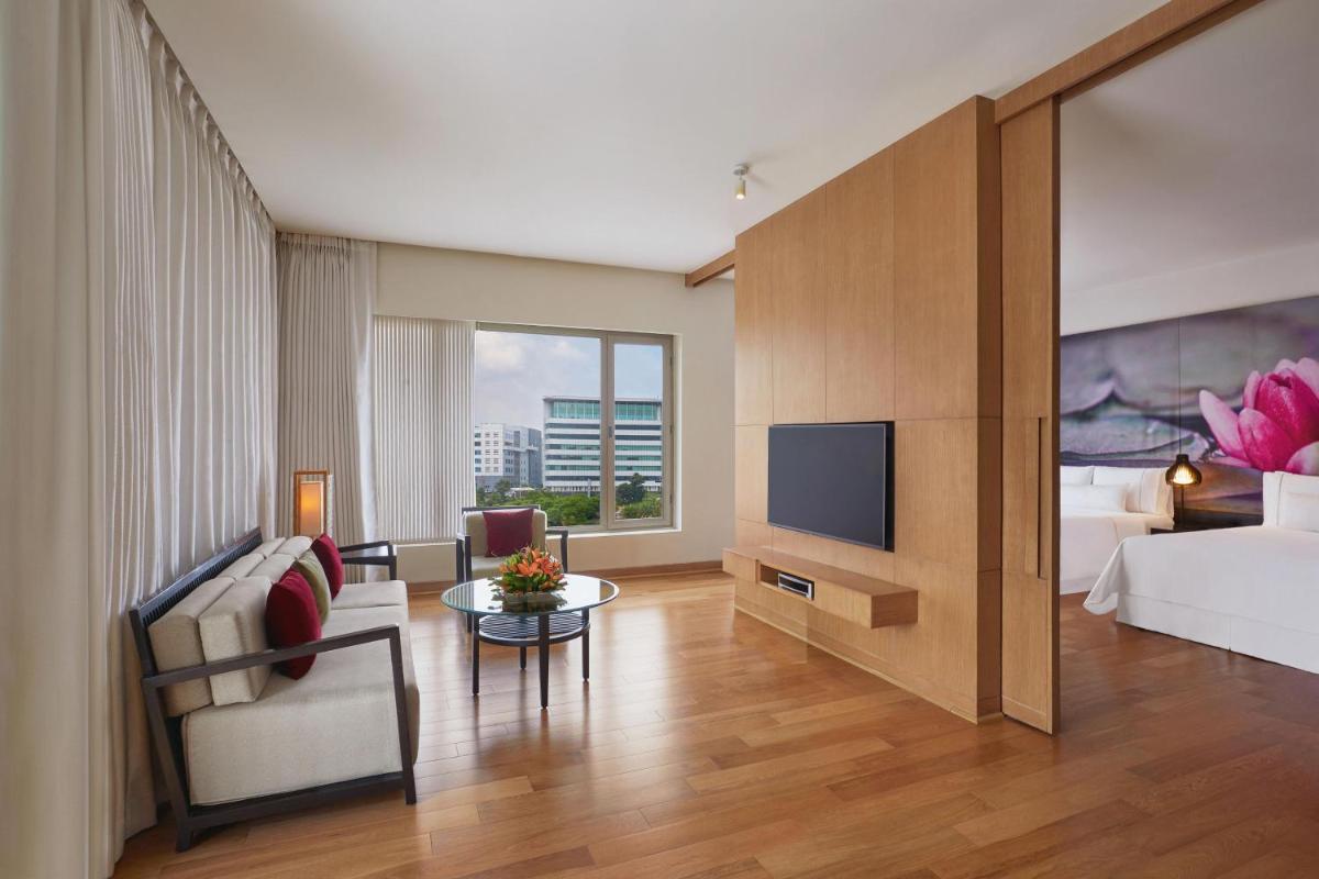 a room with a bed and a living room with a tv at The Westin Hyderabad Mindspace in Hyderabad