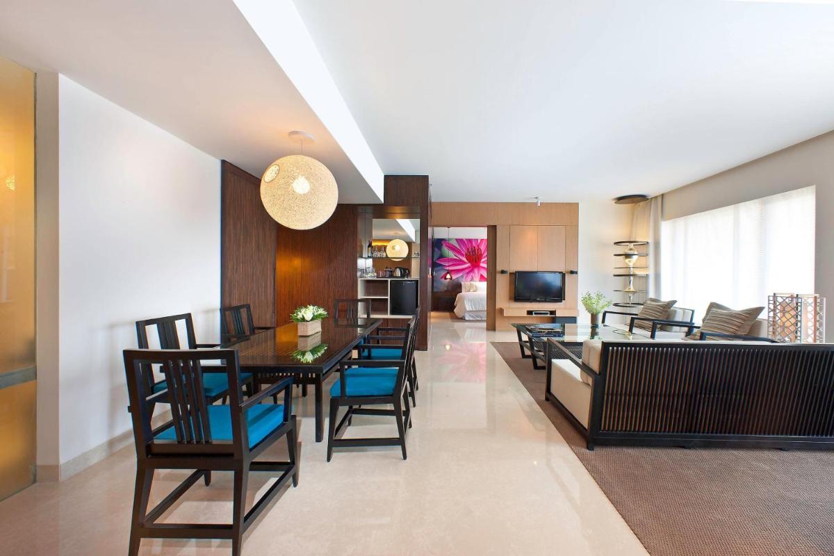 a dining room and living room with a table and chairs at The Westin Hyderabad Mindspace in Hyderabad