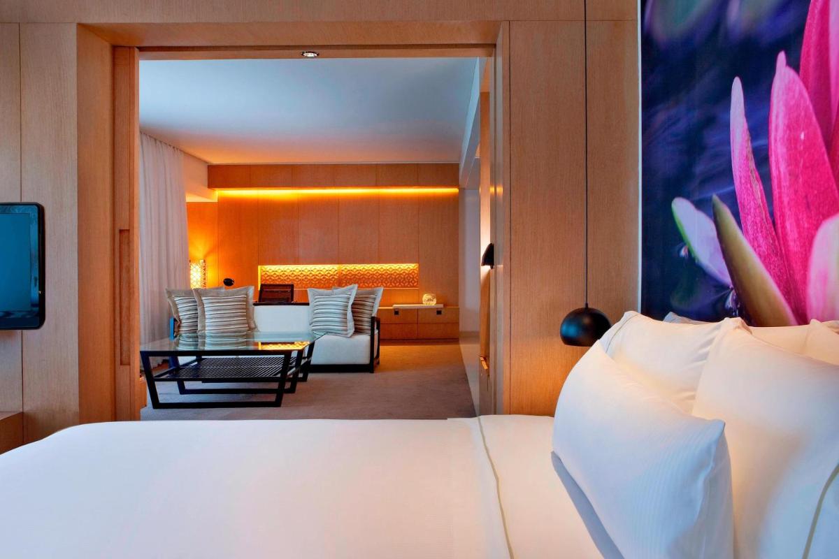 a hotel room with a bed and a living room at The Westin Hyderabad Mindspace in Hyderabad
