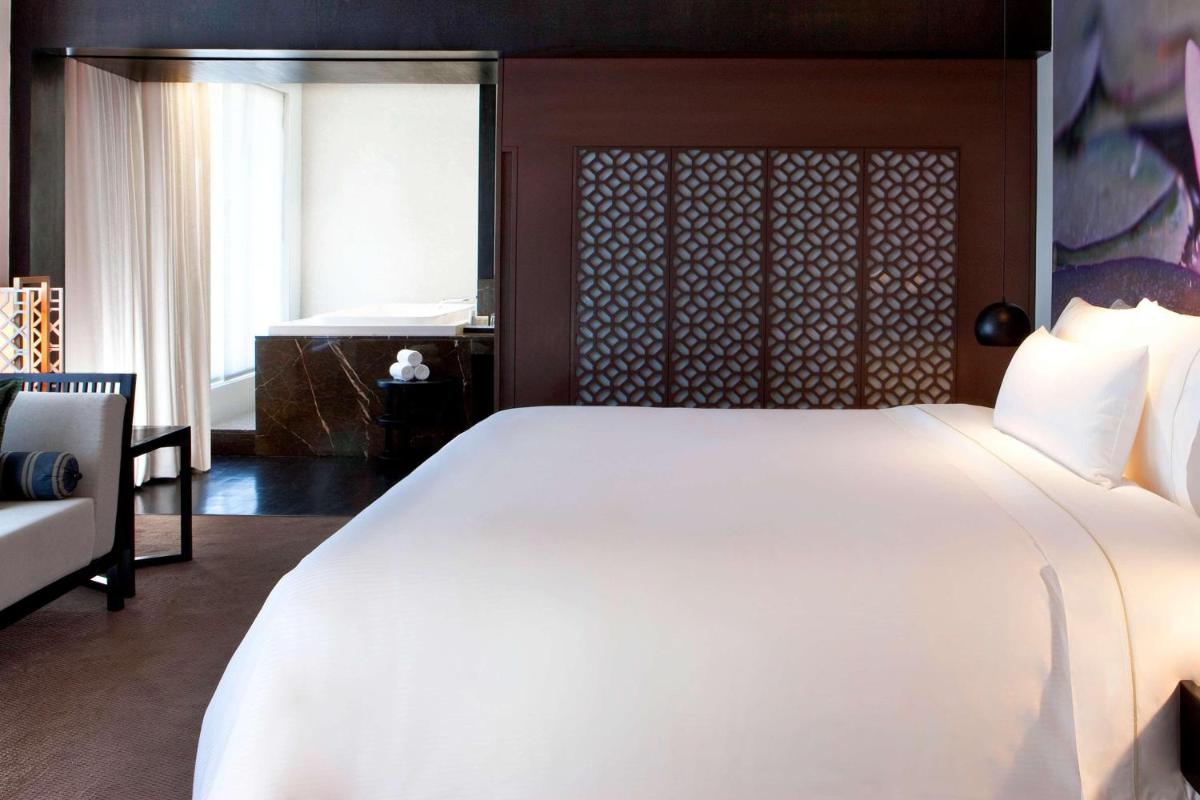 a bedroom with a large white bed and a window at The Westin Hyderabad Mindspace in Hyderabad