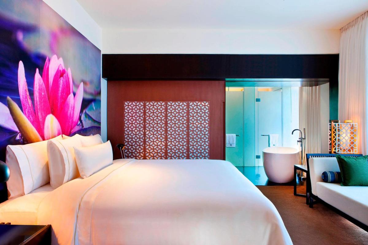 a bedroom with a large bed and a bath tub at The Westin Hyderabad Mindspace in Hyderabad