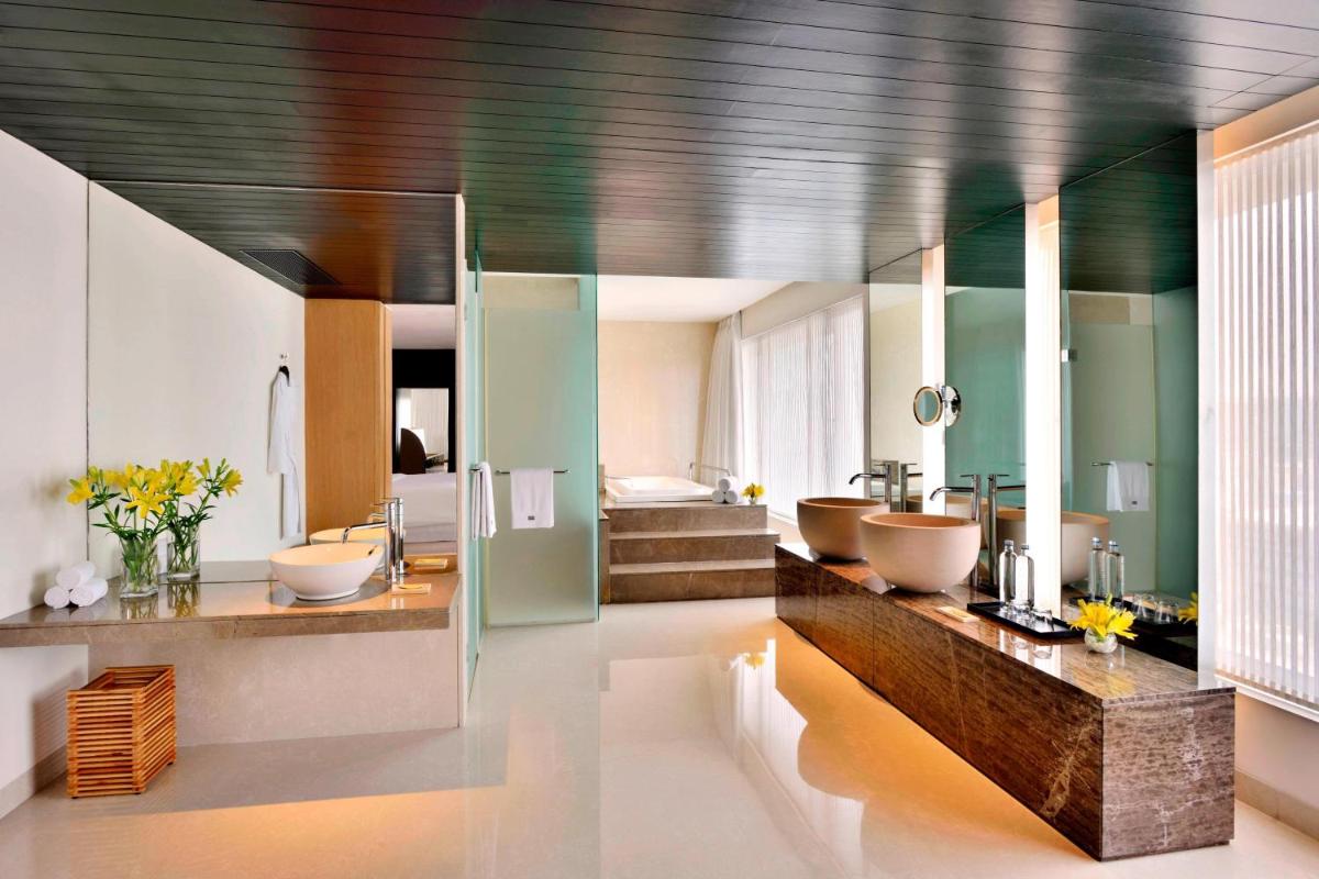 a bathroom with two sinks and a bathroom with a tub at The Westin Hyderabad Mindspace in Hyderabad