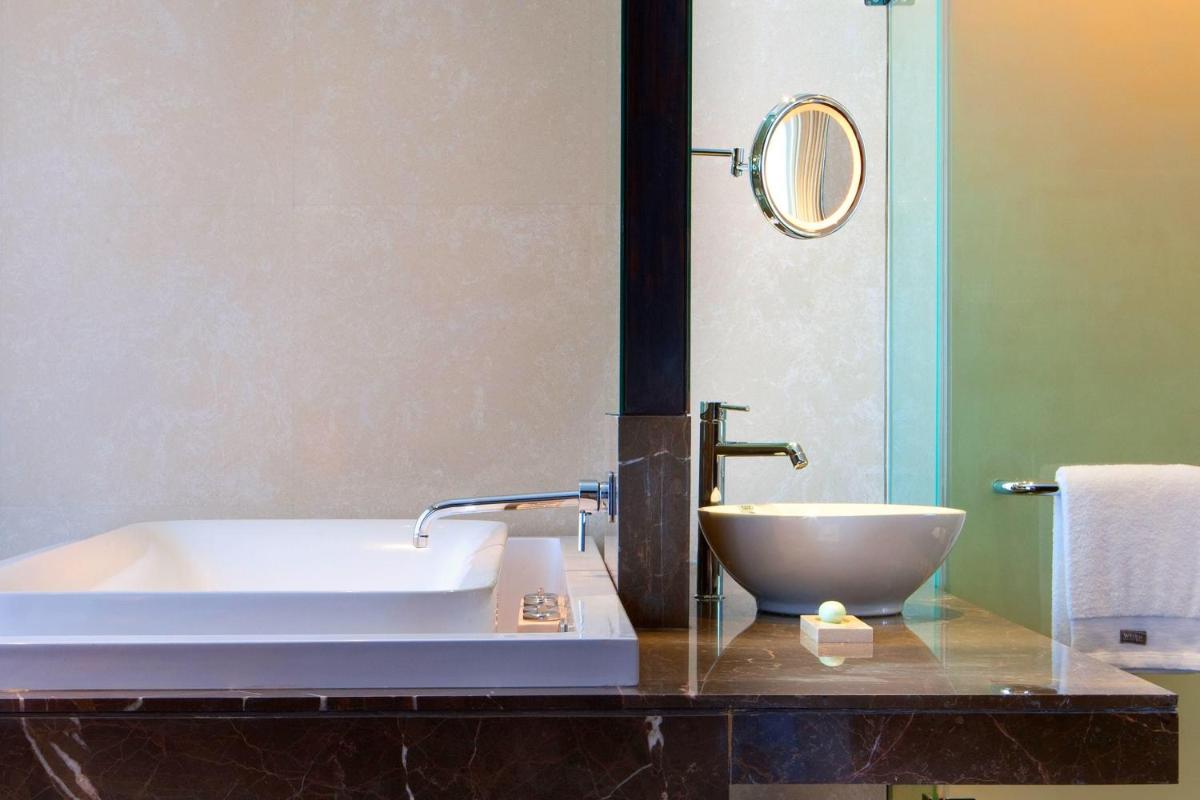 a bathroom with a sink and a bath tub at The Westin Hyderabad Mindspace in Hyderabad