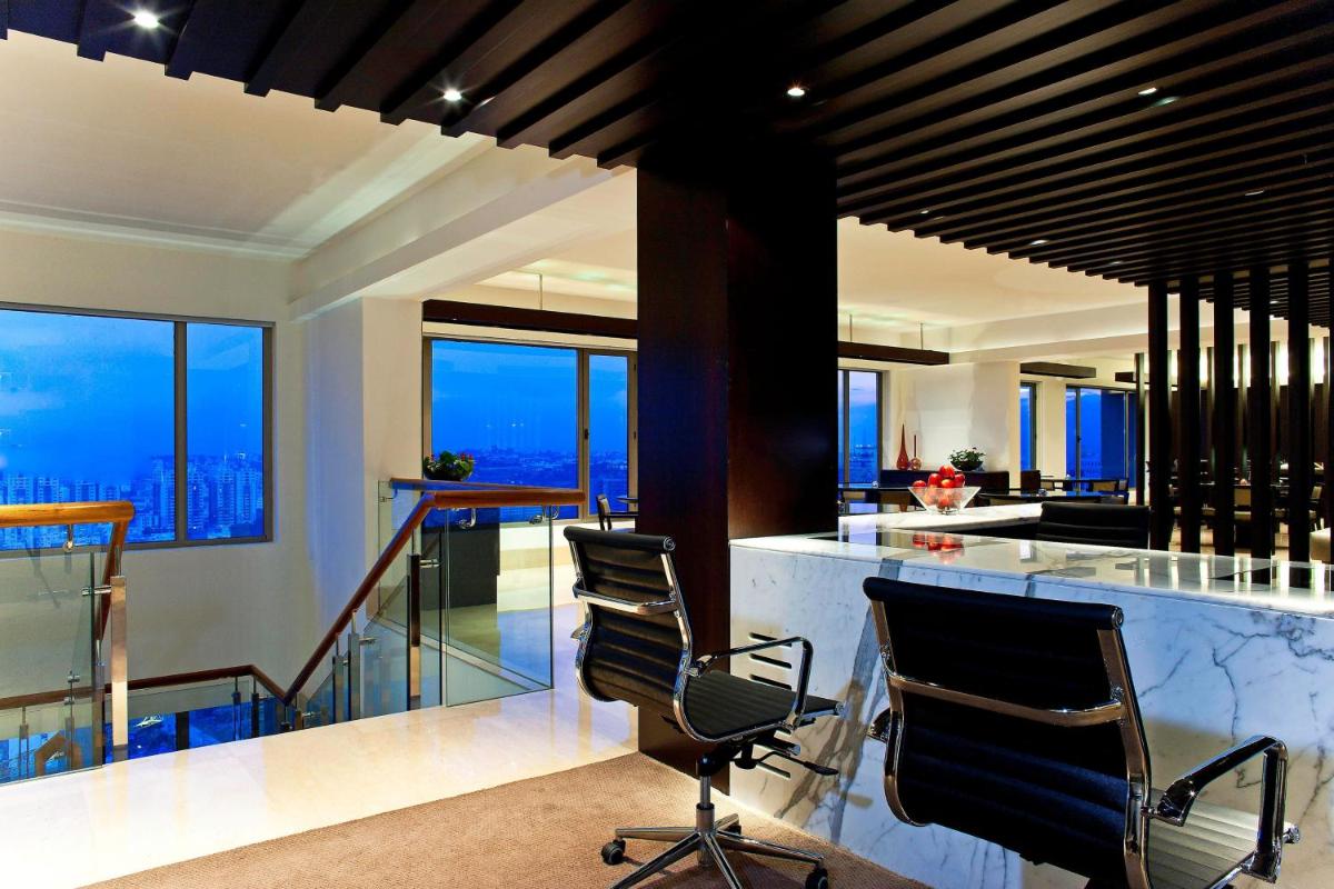 a kitchen with chairs and a bar with a view at The Westin Hyderabad Mindspace in Hyderabad
