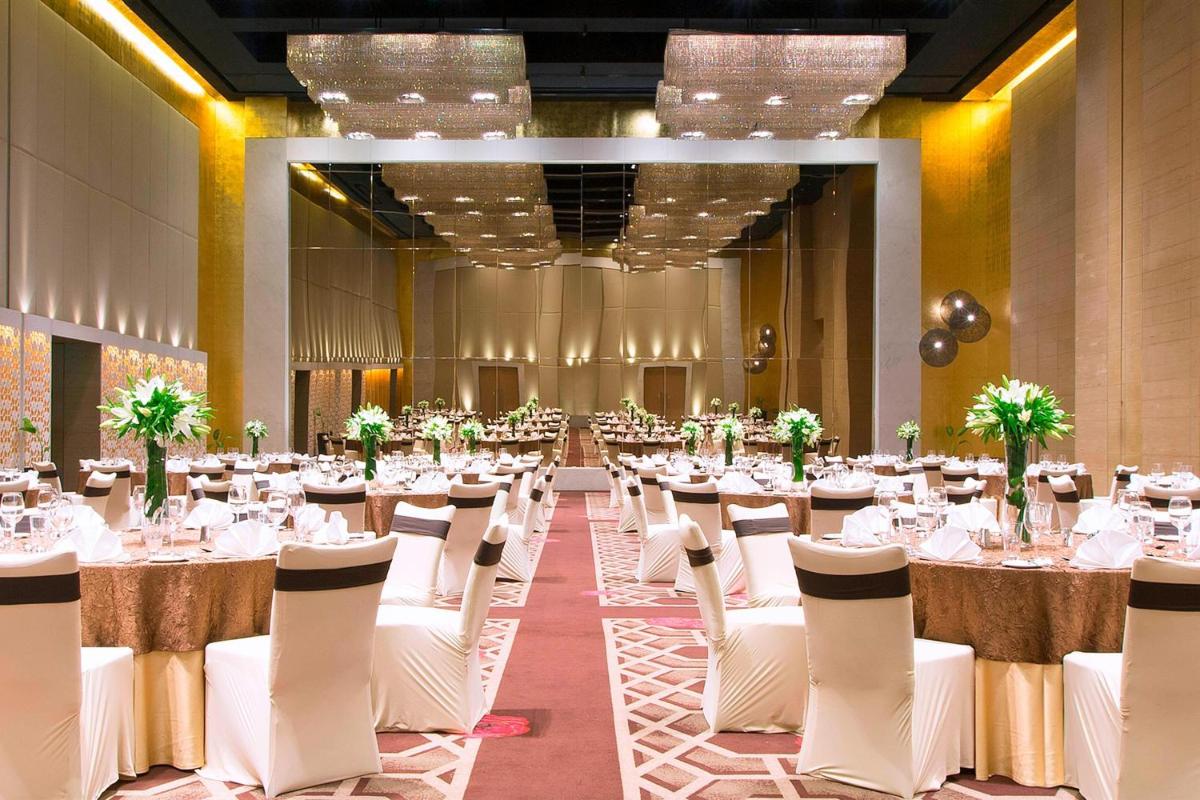 a banquet hall with white tables and chairs at The Westin Hyderabad Mindspace in Hyderabad +102 photos