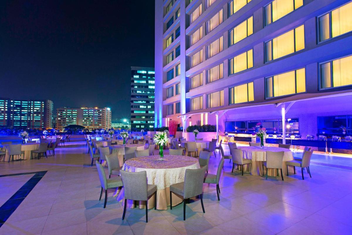 a restaurant with tables and chairs on a rooftop at night at The Westin Hyderabad Mindspace in Hyderabad