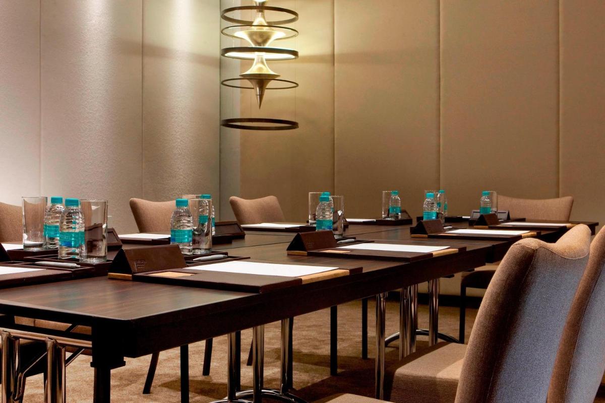 a long table with chairs and bottles of water on it at The Westin Hyderabad Mindspace in Hyderabad