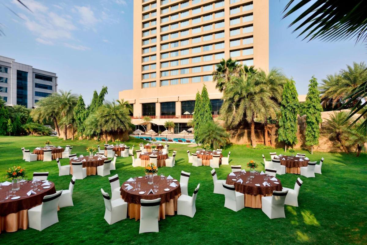 a group of tables and chairs in front of a building at The Westin Hyderabad Mindspace in Hyderabad
