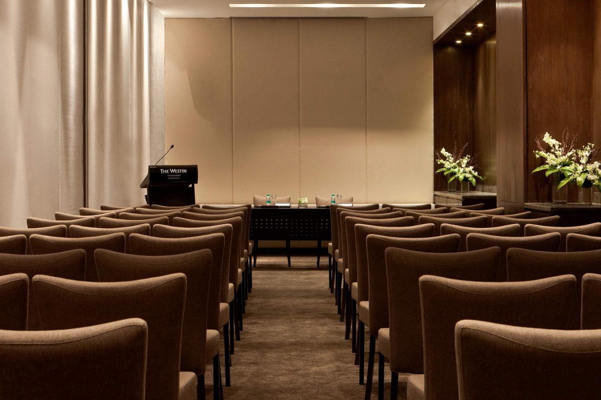 a conference room with chairs and a podium at The Westin Hyderabad Mindspace in Hyderabad