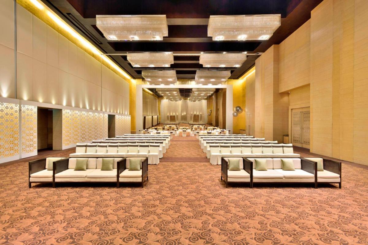 a large banquet hall with white chairs and tables at The Westin Hyderabad Mindspace in Hyderabad