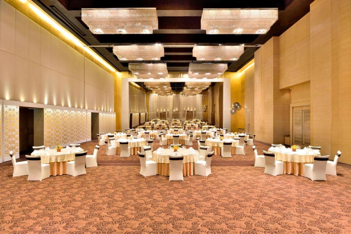 a large banquet hall with white tables and chairs at The Westin Hyderabad Mindspace in Hyderabad