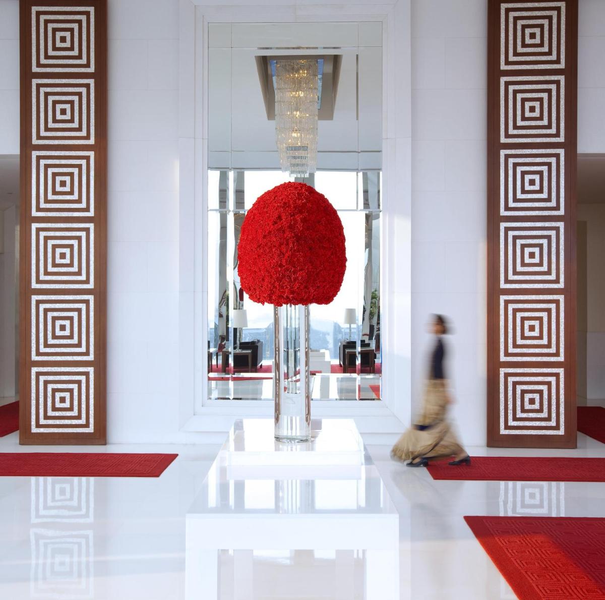 a person walking through a lobby with a large red ball at The Oberoi Gurgaon in Gurgaon