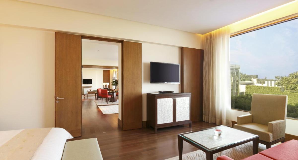 a living room with a couch and a tv at The Oberoi Gurgaon in Gurgaon