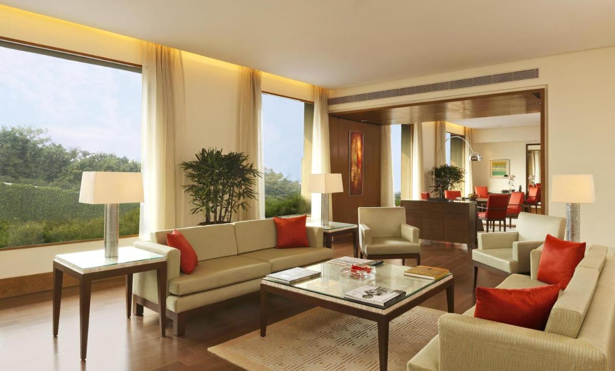 a living room filled with furniture and a large window at The Oberoi Gurgaon in Gurgaon