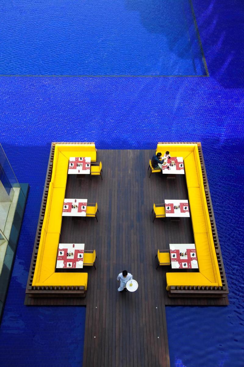 two yellow benches in a swimming pool at The Oberoi Gurgaon in Gurgaon