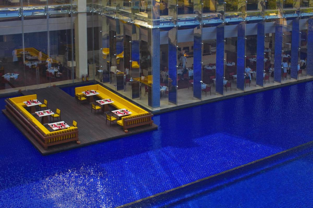 a lego room with tables and a swimming pool at The Oberoi Gurgaon in Gurgaon