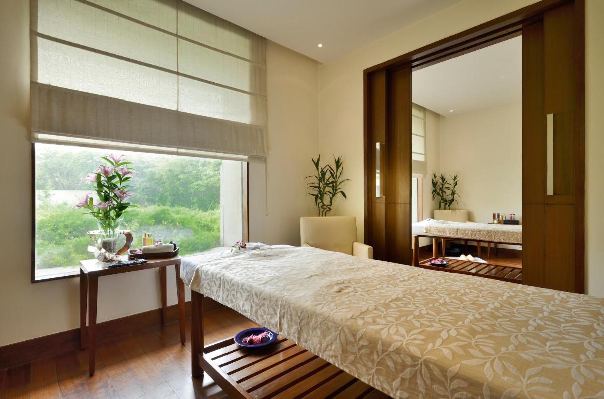 a bedroom with a large bed and a large window at The Oberoi Gurgaon in Gurgaon