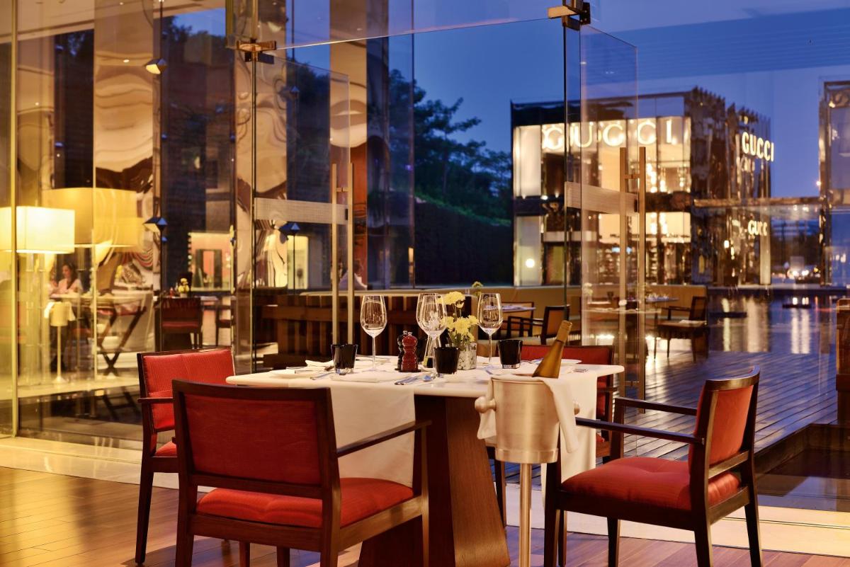 a restaurant with a table with wine glasses on it at The Oberoi Gurgaon in Gurgaon
