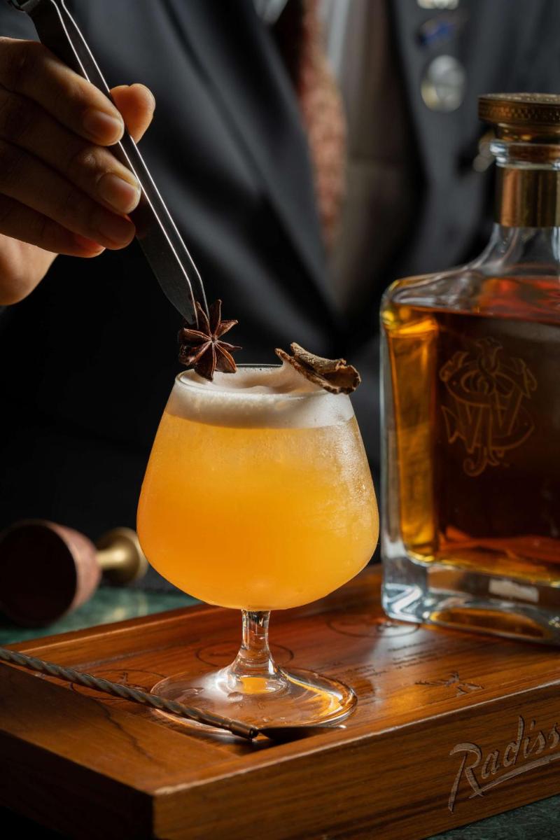 a person is stirring a drink with a spoon at Radisson Blu Plaza Delhi Airport in New Delhi a person is stirring a drink with a spoon at Radisson Blu Plaza Delhi Airport in New Delhi