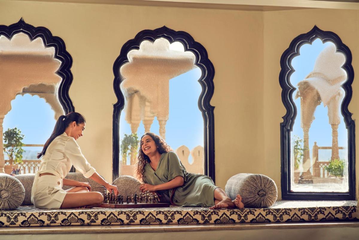 two women sitting on a couch in front of a cake at Fairmont Jaipur in Jaipur