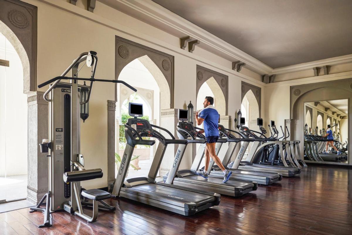 a woman walking on a treadmill in a gym at Fairmont Jaipur in Jaipur