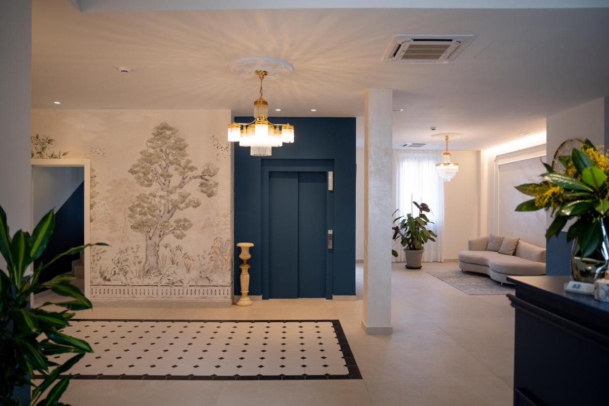 un pasillo con una puerta azul y un sofá en Hotel Boutique Las Indianas, en Nueva de Llanes