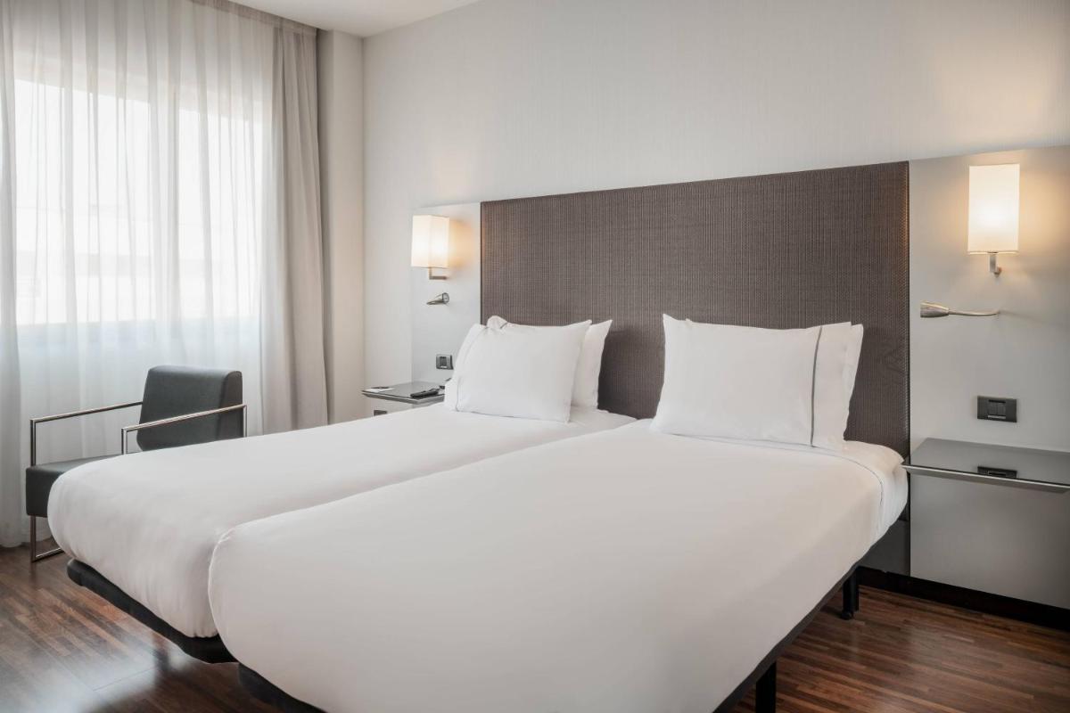 Una gran cama blanca en una habitación de hotel. en AC Hotel San Sebastián de los Reyes by Marriott, en San Sebastián de los Reyes