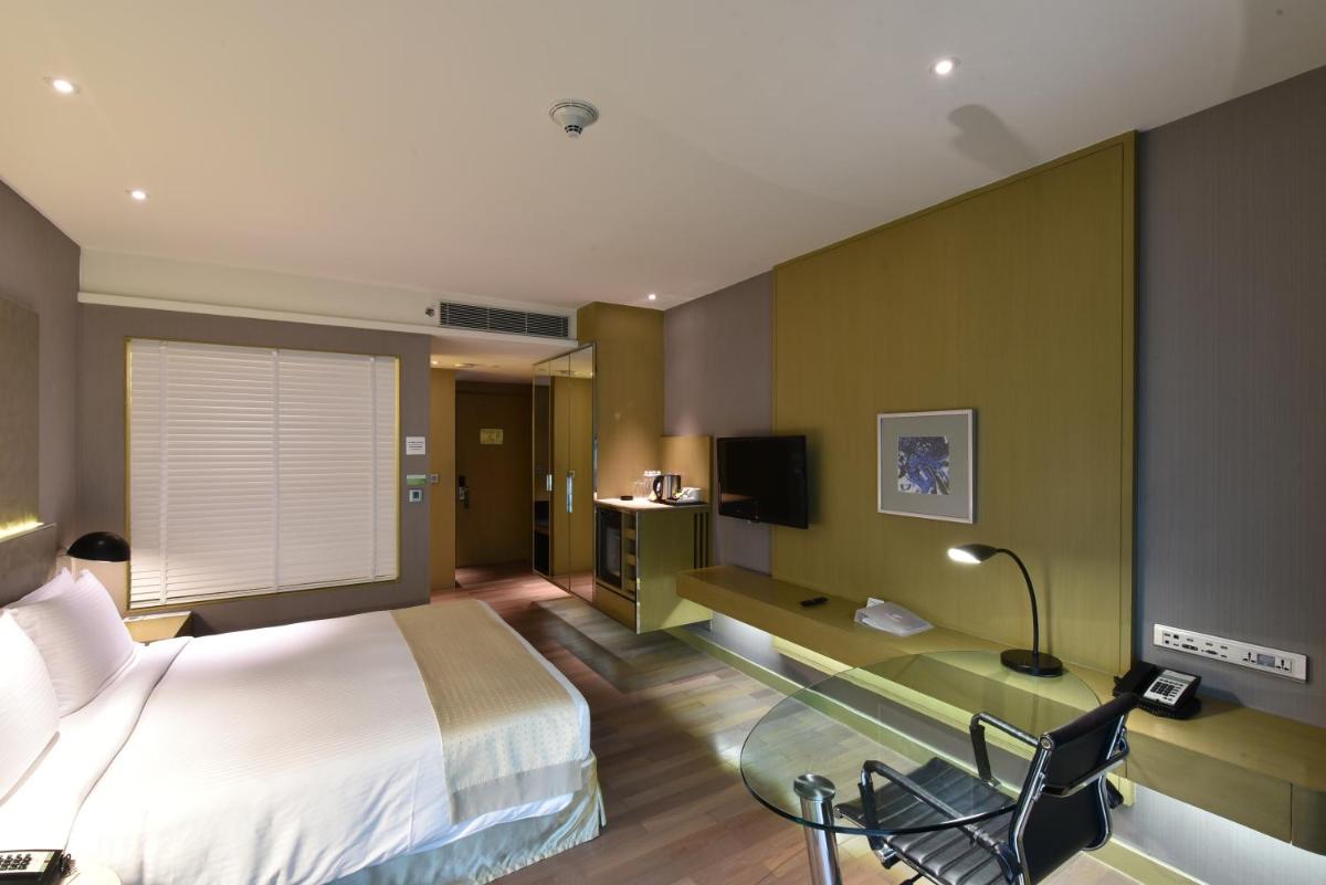 a bedroom with a bed and a desk and a tv at Holiday Inn New Delhi Aerocity by IHG in New Delhi